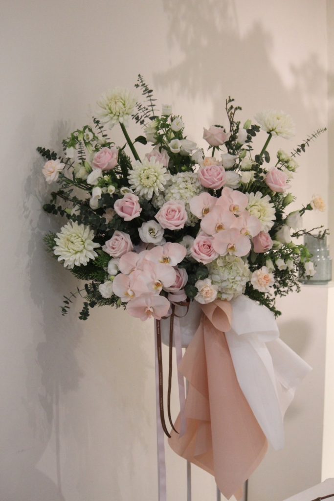 Bloom & Grace 實品作品:粉玫瑰與淡粉蝴蝶蘭搭配白花的粉白高架祝賀花籃